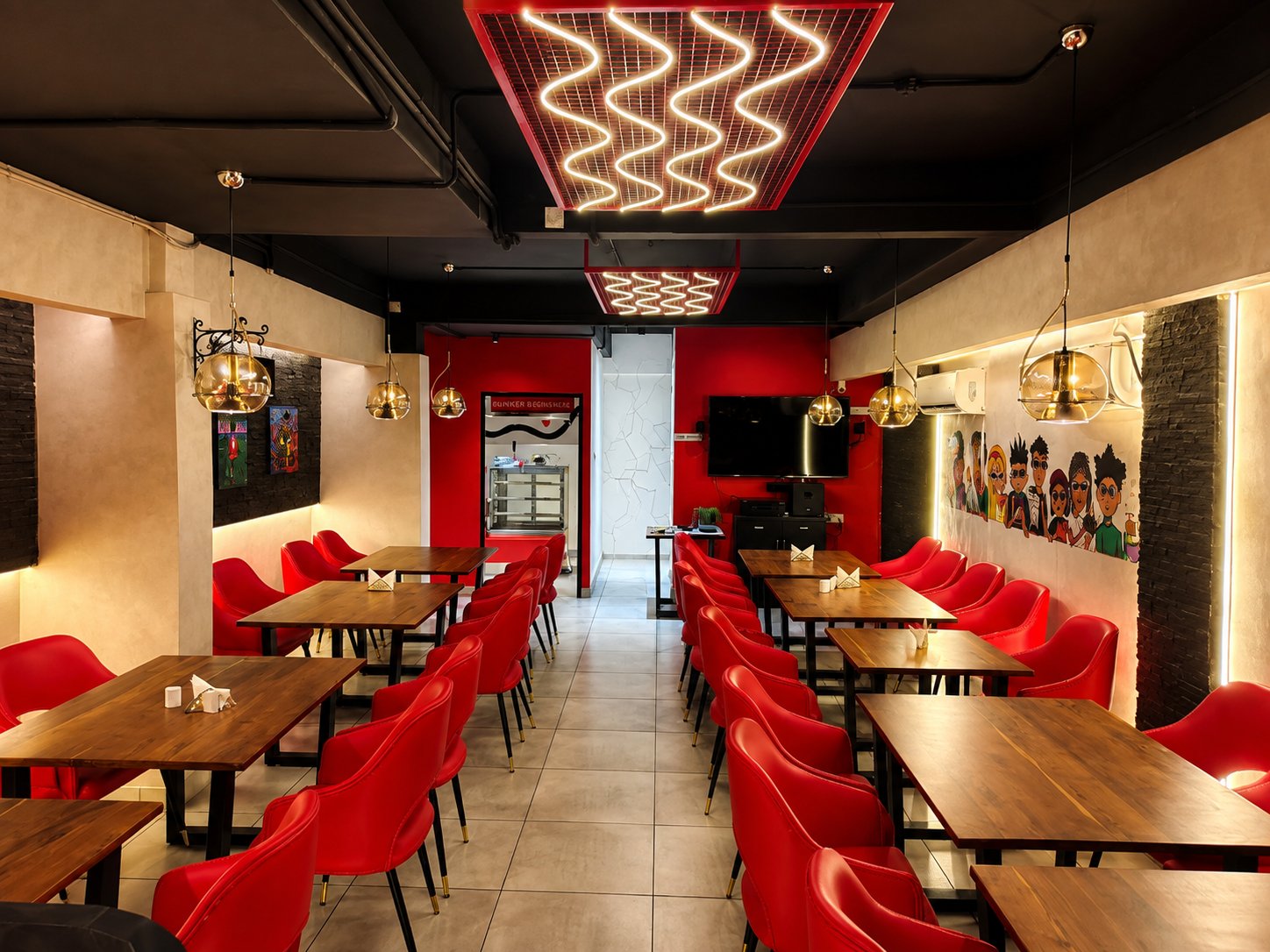 Open Crave Bunker dining room interior with red seating and neon lighting